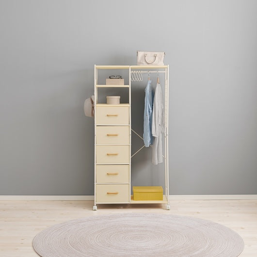 ホワイトのファブリック収納付きハンガーラックに洋服や帽子がかけられている様子