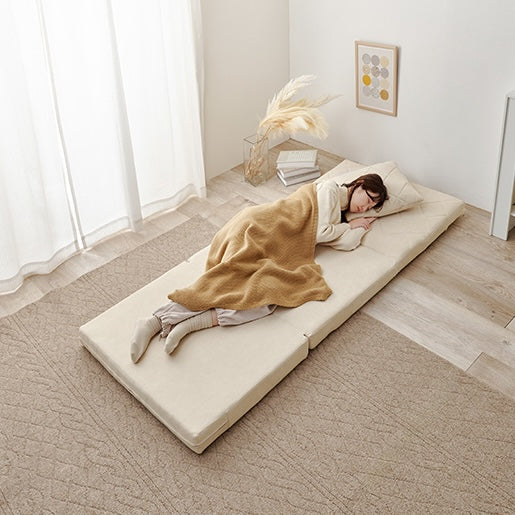 キルティングソファベッドアイボリーをベッドとして使って寝ている様子