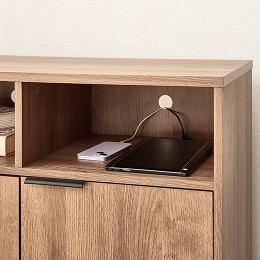 ブラウンの木目調のキャビネットでスマホとタブレットの充電をしている様子