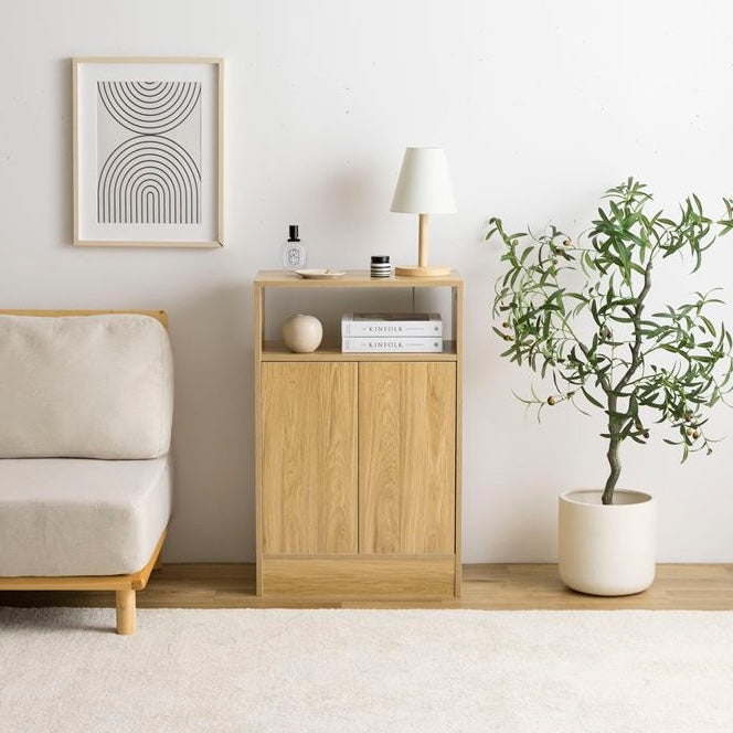 ナチュラルウッドの扉付きの収納とオープン棚が組み合わさったキャビネットを部屋の中でソファの横に置いている