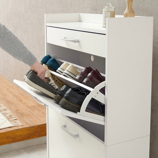 ホワイトのフラップ扉式のシューズケースから靴を取り出している様子
