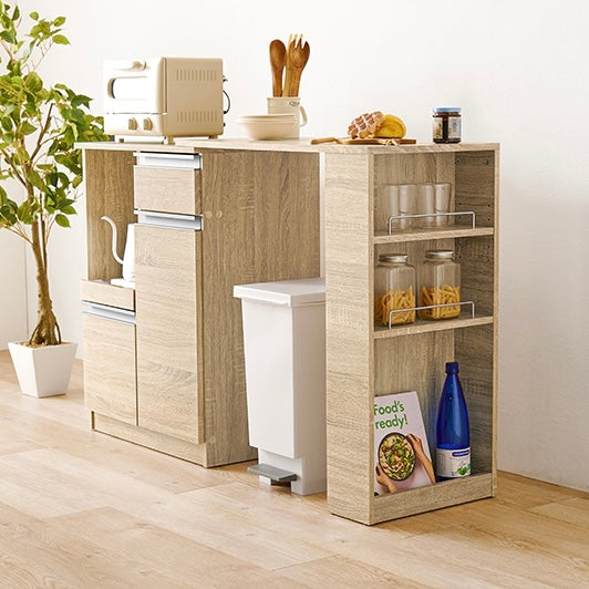 ホワイトのキッチンボードに調理器具やストック品が収納されている様子