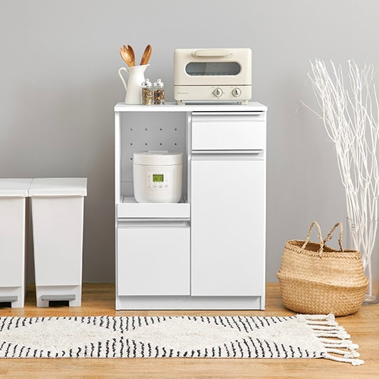 ホワイトのキッチンボードに調理器具やストック品が収納されている様子