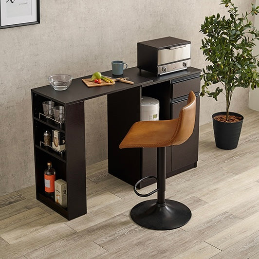 ナチュラルのキッチンボードの前にカウンターチェアを置いている様子