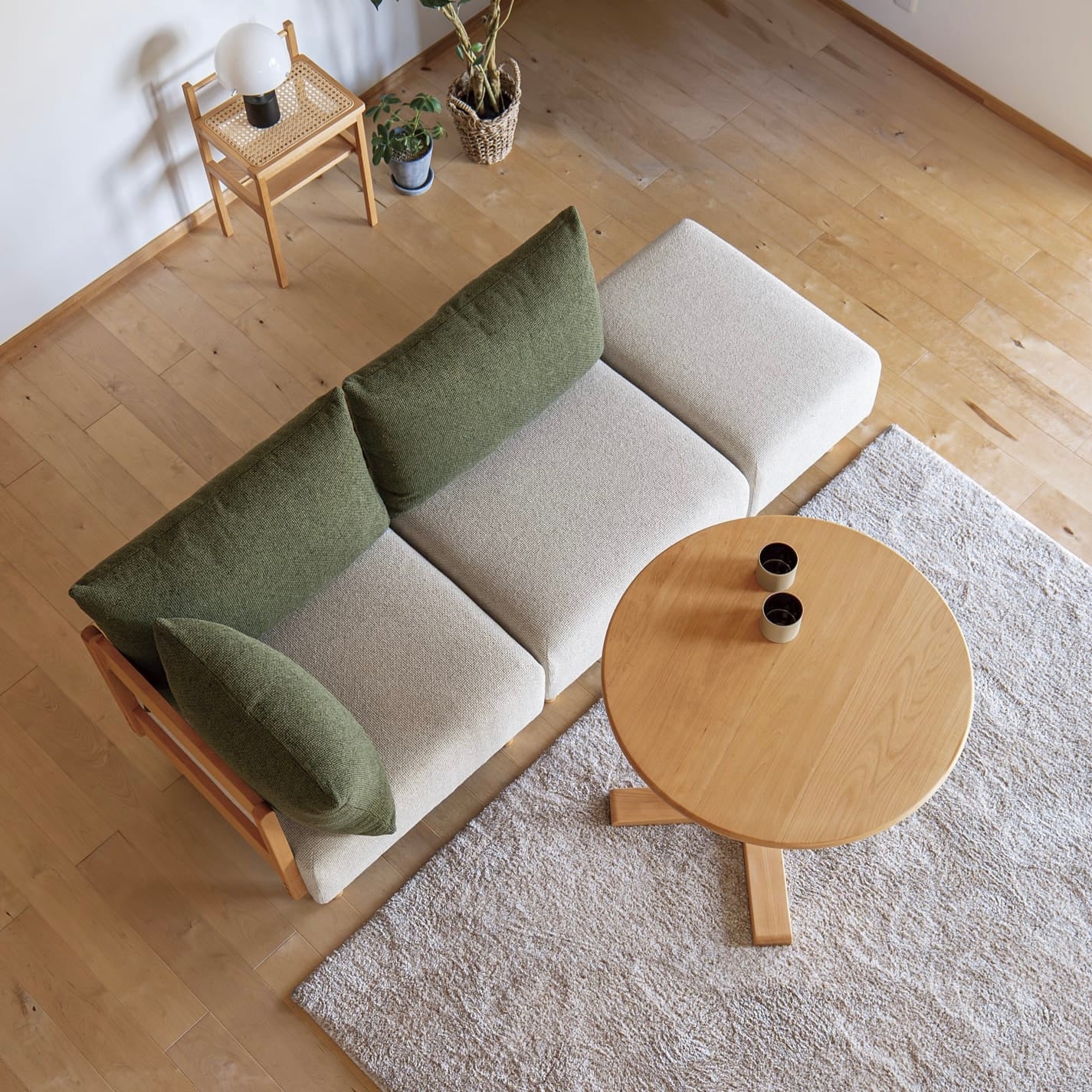 木製フレームのモスグリーンのソファがリビングに置かれている様子