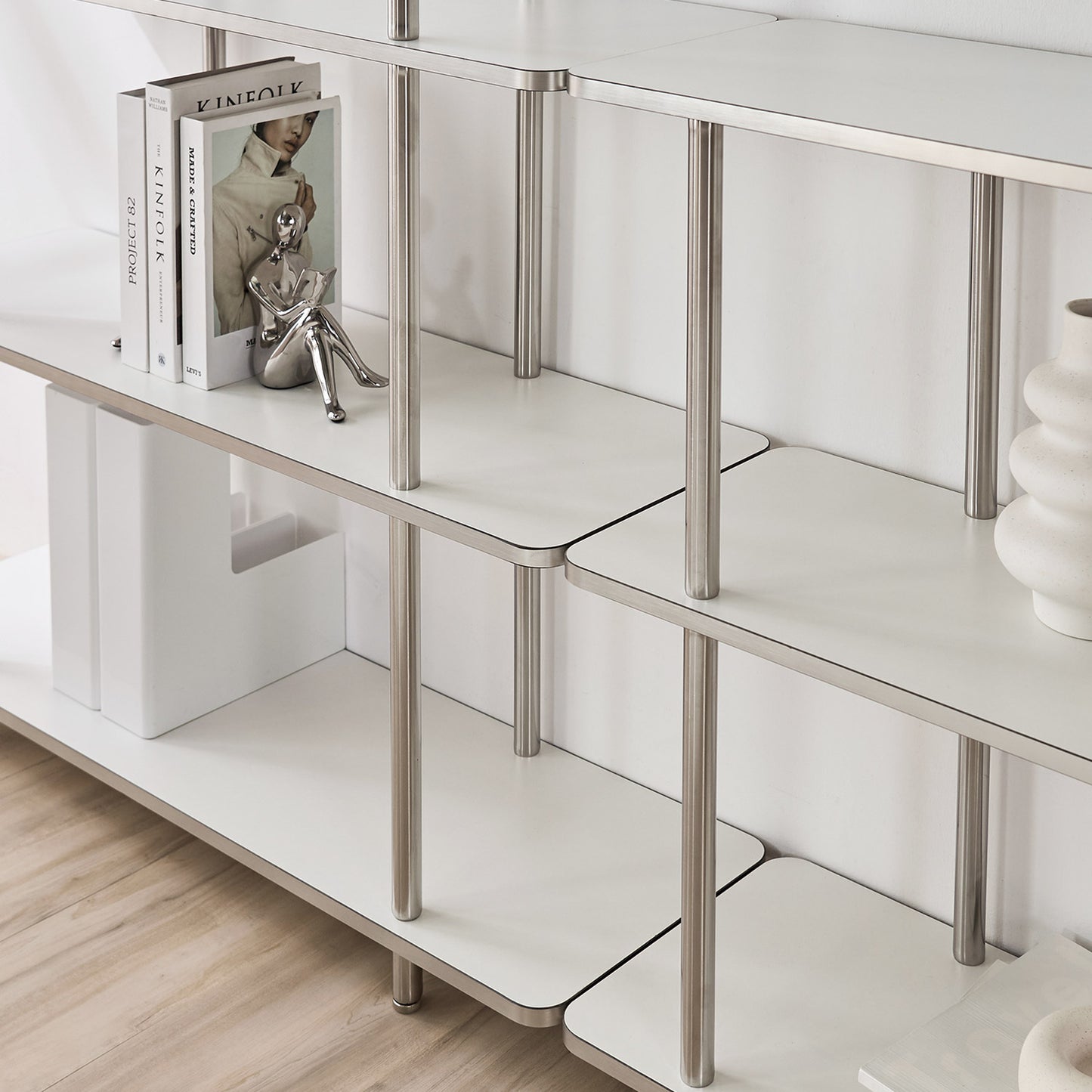 ホワイトのオープンシェルフに花瓶や本などが置かれている様子