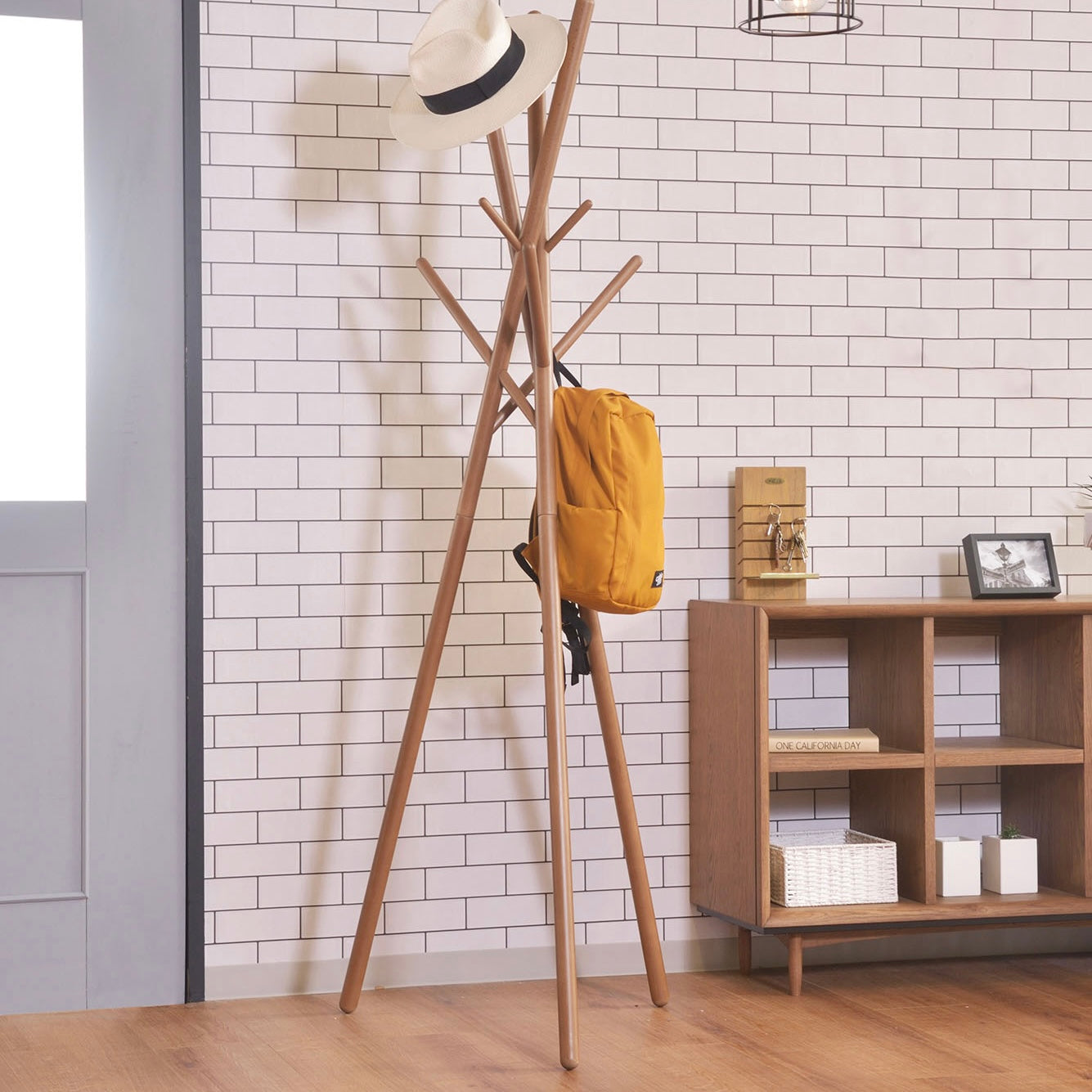 木の枝が交差したようなデザインのハンガーラックに帽子とリュックがかけられている