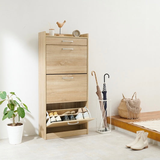 ナチュラルのフラップ扉式シューズケースを玄関に置いている様子