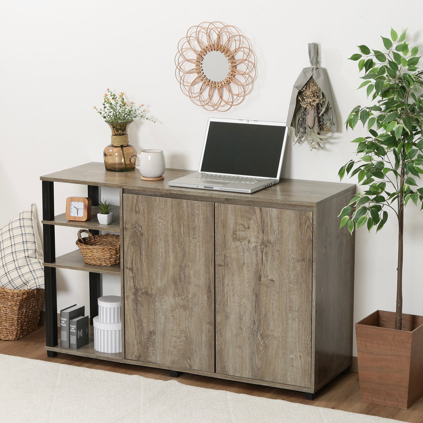 オープンラックが一体になった、ウッド素材のキャビネットの上にパソコンや植物が置かれている様子