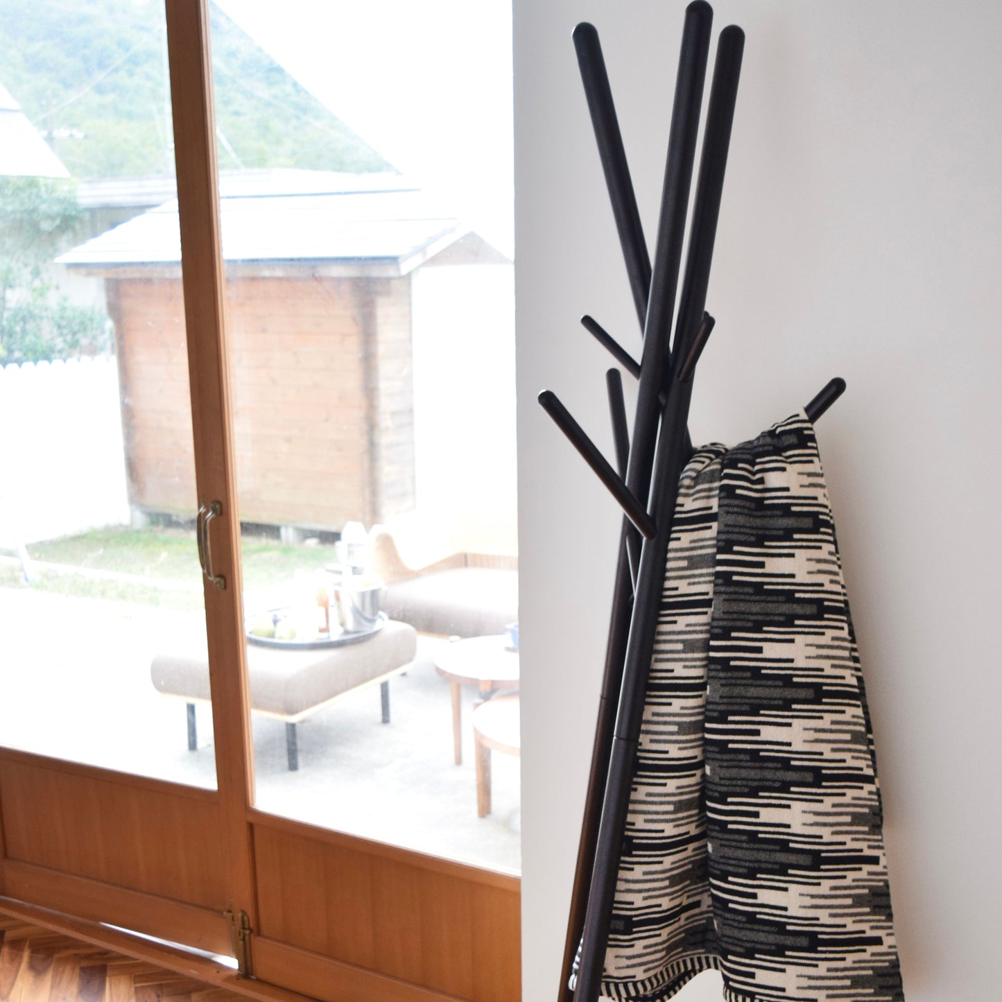 木の枝が交差したようなデザインのハンガーラックにブランケットが掛けられている