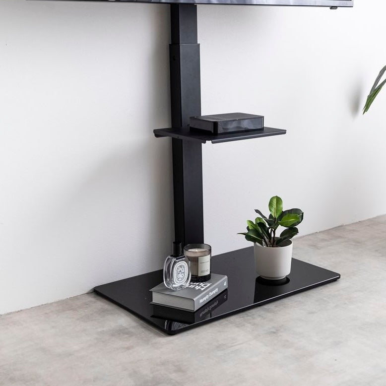 ラック付きのブラックのテレビスタンドが壁に寄せられている様子