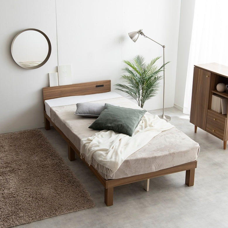 天然木製のブラウンのヘッドボードに2口コンセントが付いたシンプルなベッドフレームを部屋で使っている