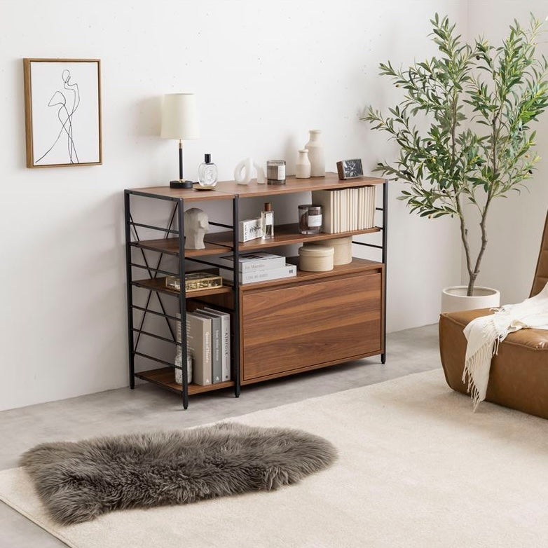 ブラウンの棚板とブラックの支柱デザインの引き出し付きのワイドなオープンラックを部屋に置いてライトやオブジェをディスプレイしている