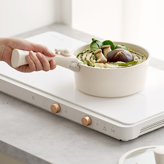 取手も蓋も本体も真っ白でお洒落な鍋をIHで火にかけているところ