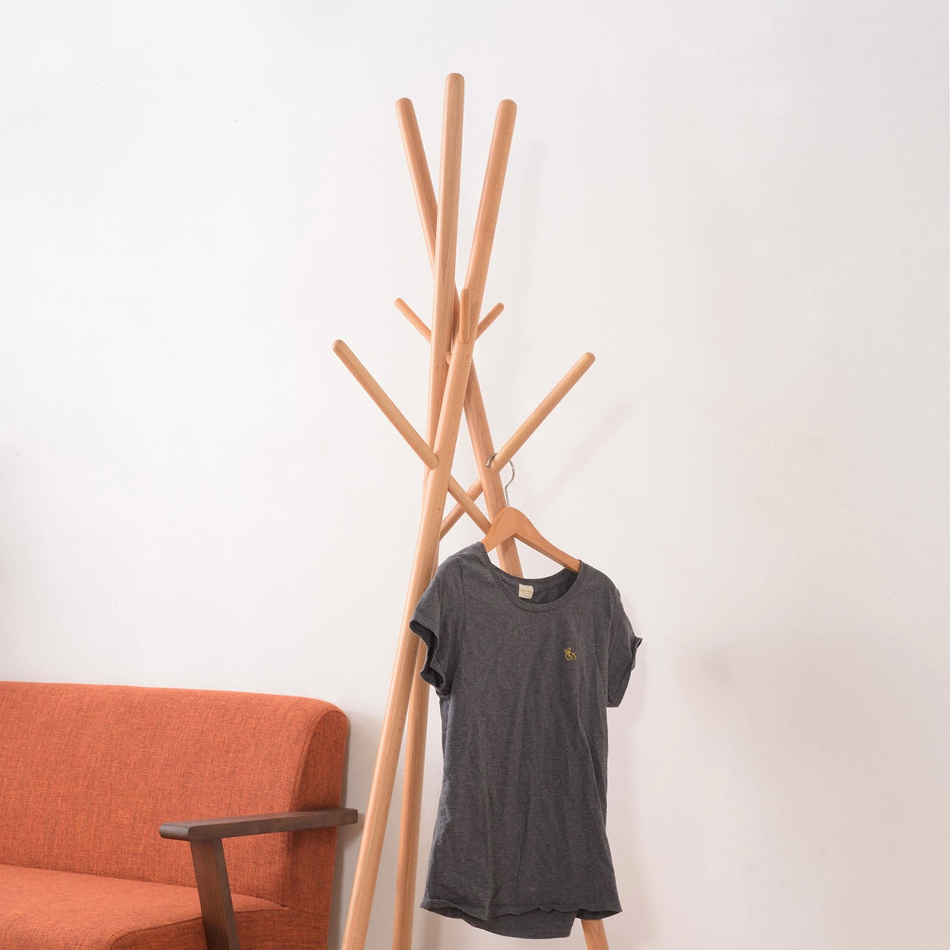 木の枝が交差したようなデザインのハンガーラックに服がかけられている