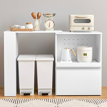 ホワイトのキッチンボードに調理器具やストック品が収納されている様子