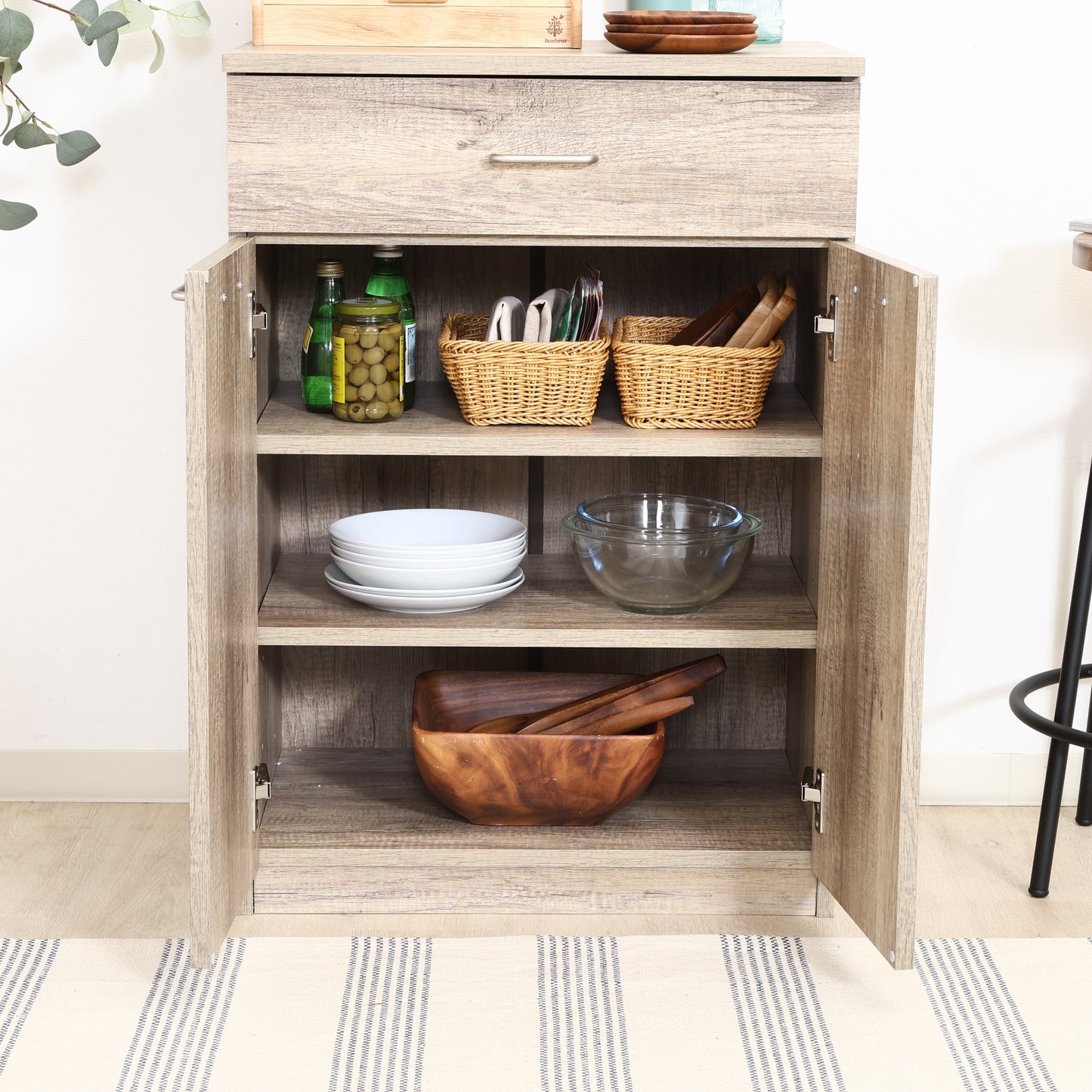 ユニット収納キャビネットグレーの扉収納に食器が置かれている様子