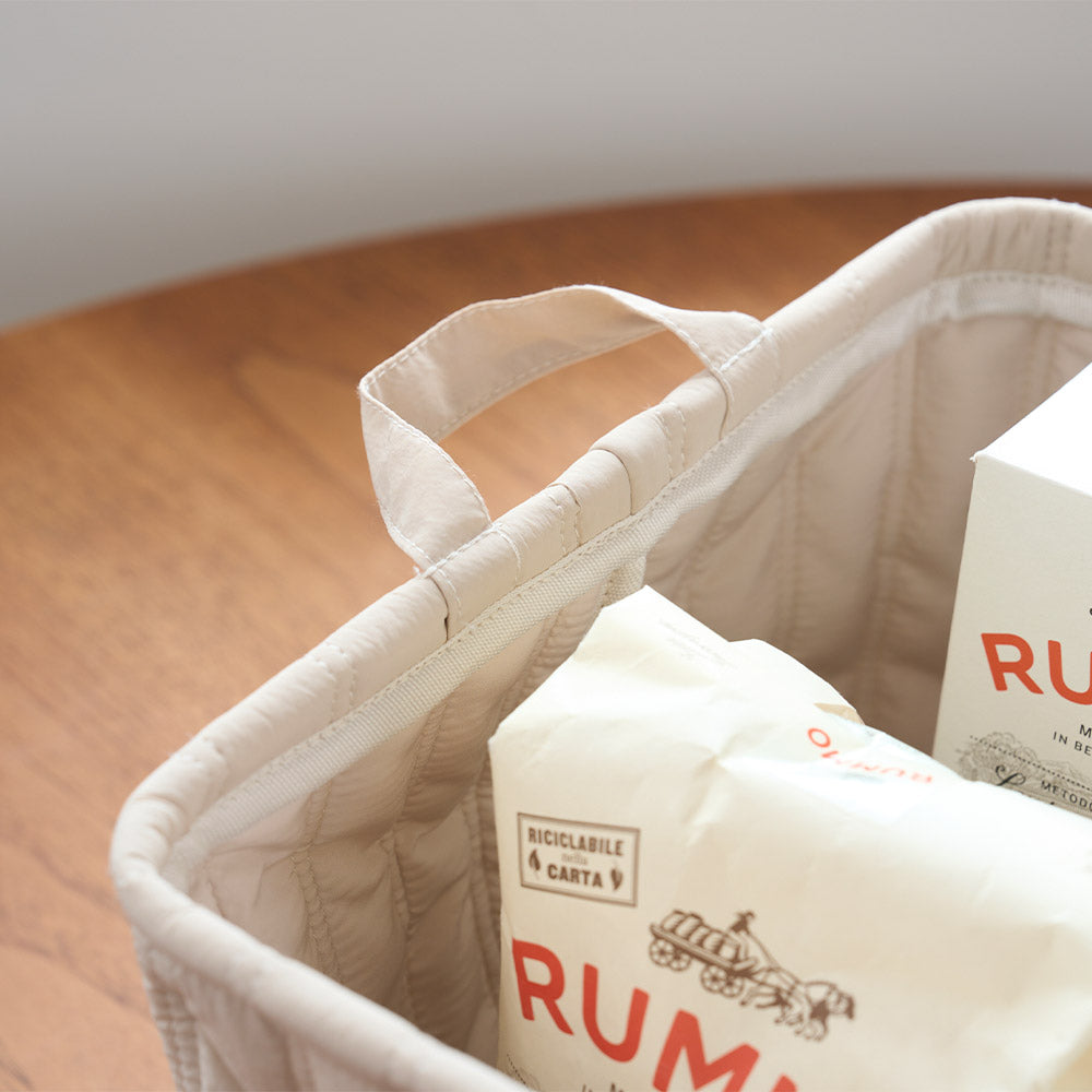 キルティング素材のベージュのバスケットの取手部分