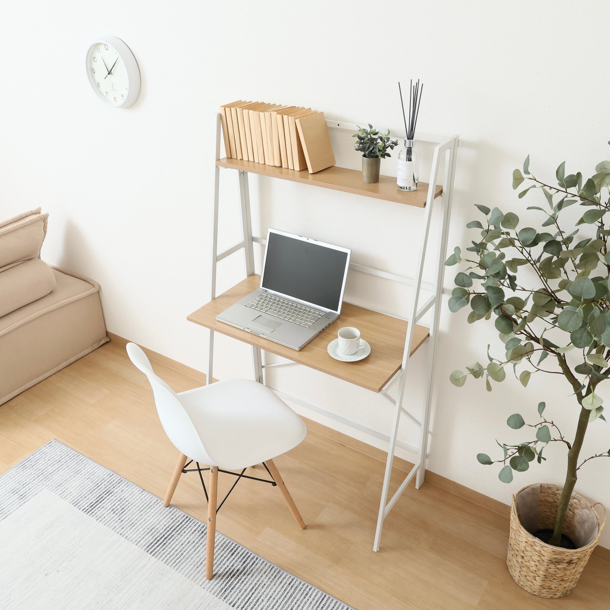 収納棚が付いた折りたたみ式のデスクにパソコンや本が置かれている様子