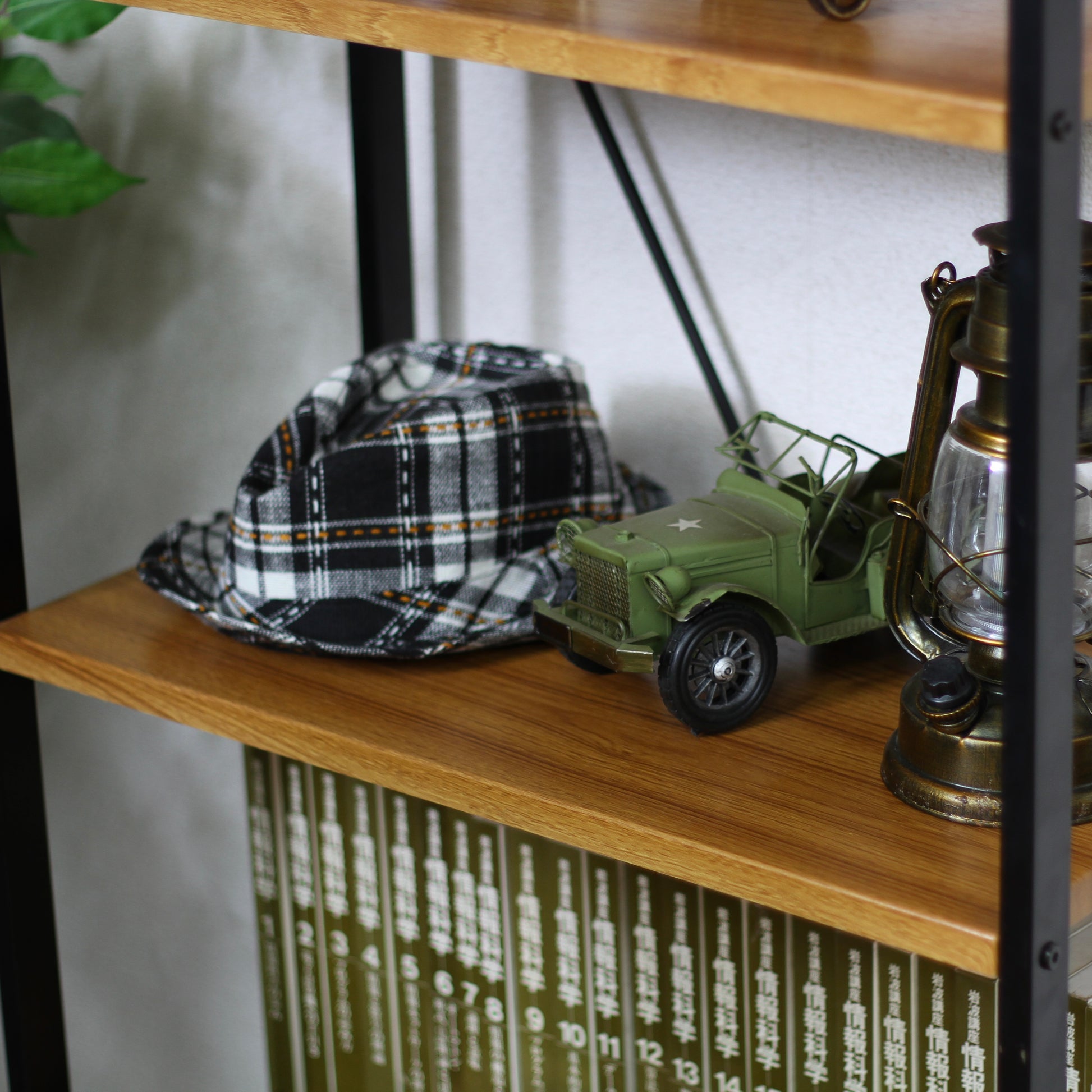 ウッド素材の天板と黒スチールのフレームの4段シェルフの上にお気に入りアイテムが置かれている様子