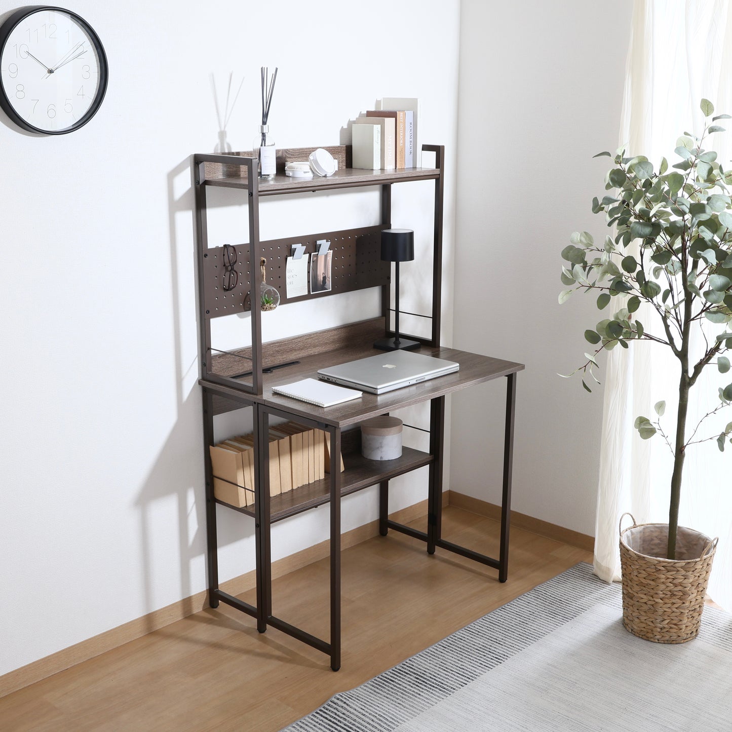 天板が折りたためる収納棚が付いたデスクにパソコンや本が置かれている様子