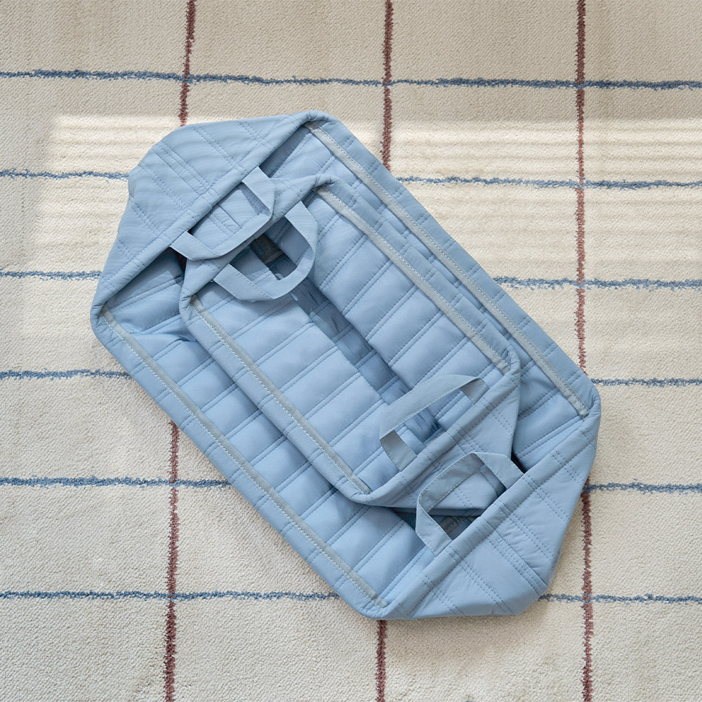キルティング素材のブルーのバスケットが折りたたまれている様子