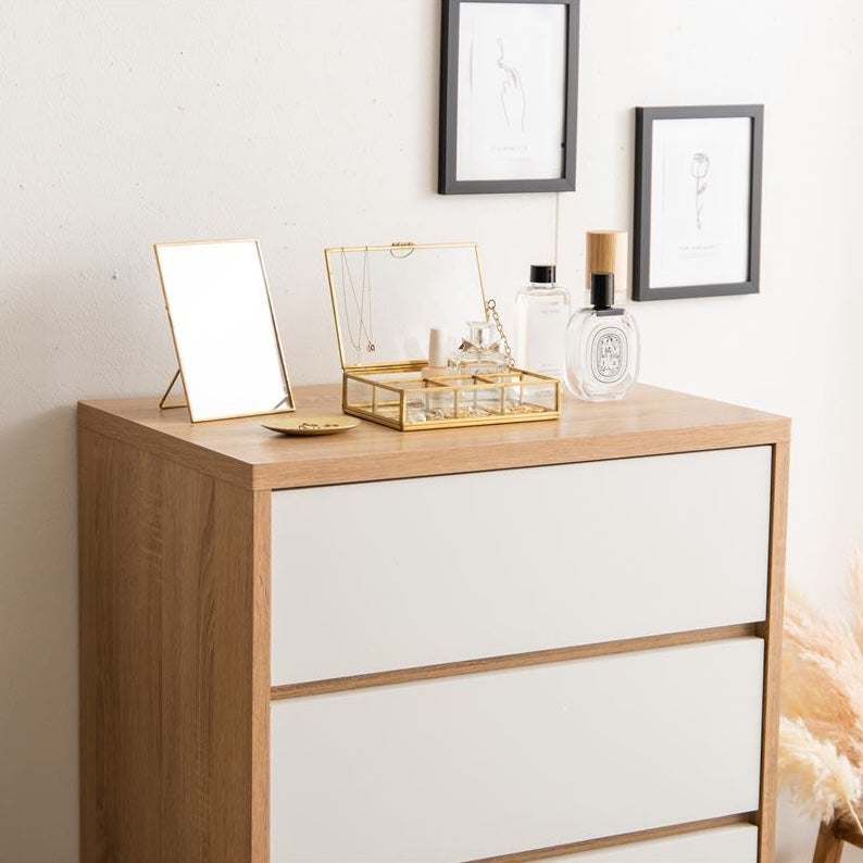 白とナチュラルウッドのバイカラーのチェストの天板にアクセサリーや香水を飾っている
