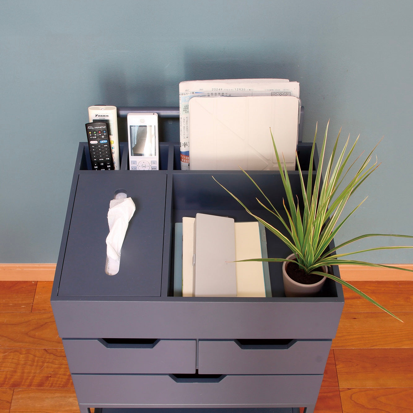 引き出しがたくさんついたネイビーのワゴンに小物やティッシュが収納されている様子