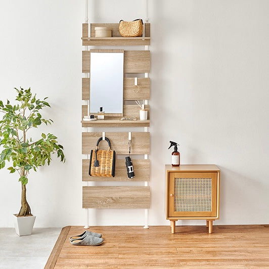 ナチュラルの突っ張りミラー付きラックを玄関に置いている様子