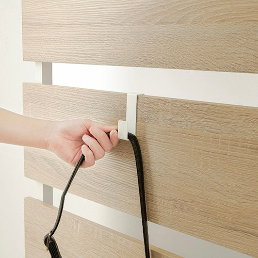 ナチュラルの突っ張りディスプレイラックにバッグをかけている様子