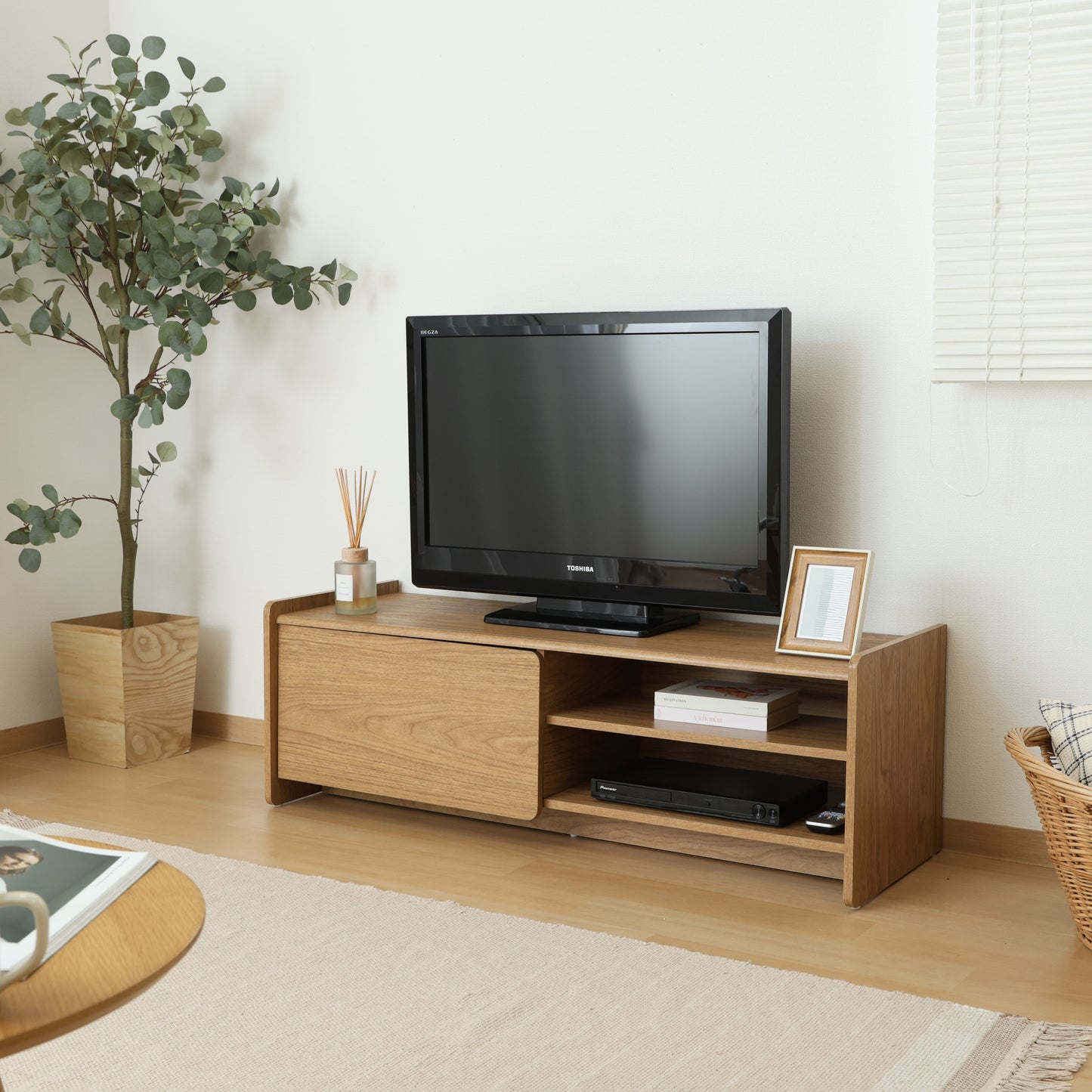 部屋のリビングにブラウンカラーの幅120cmのテレビボードが置いてある写真