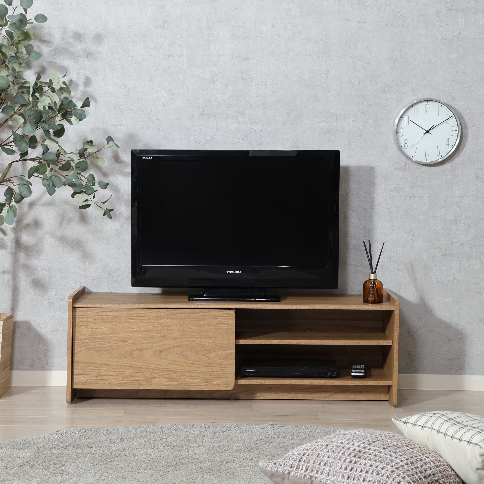 部屋のリビングにブラウンカラーの幅120cmのテレビボードが置いてある写真