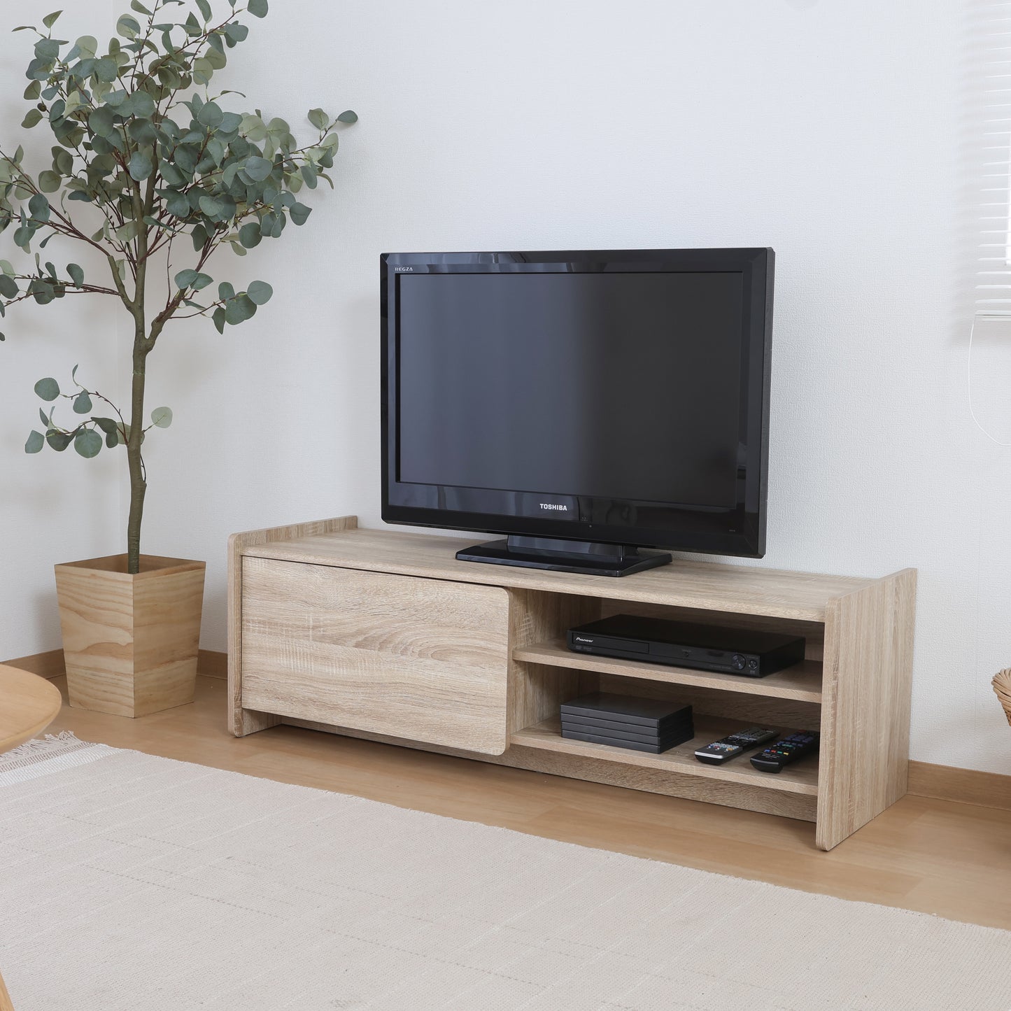 リビングにホワイトオークカラーの幅120cmのテレビボードが置いてある写真