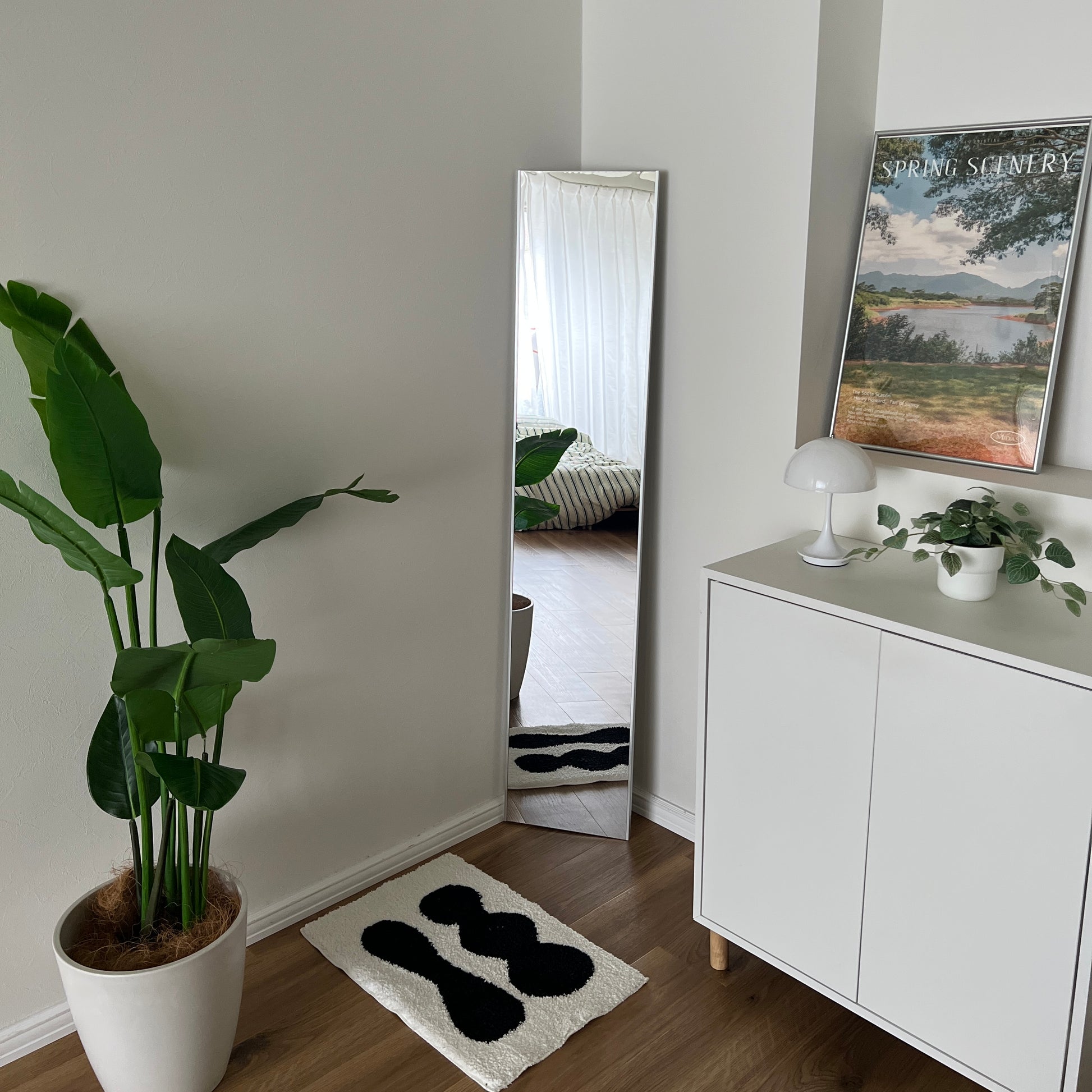 部屋の角に全身鏡を置いて、前にミニラグを敷いている様子