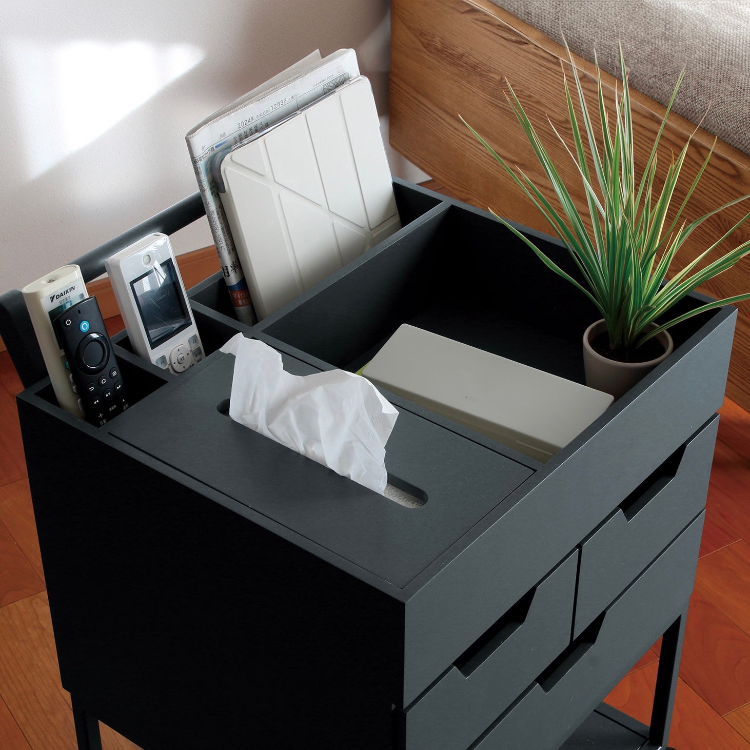 引き出しがたくさんついたネイビーのワゴンにティッシュや小物が収納されている様子