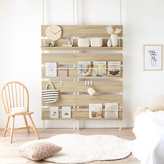 ナチュラルの突っ張りディスプレイラックをベッド横に設置している様子