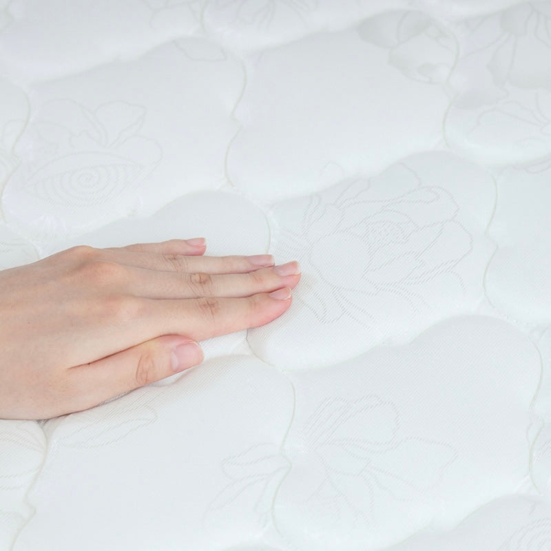 ホワイトのボンネルコイルマットレスに手を置いている様子