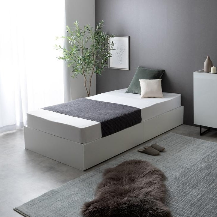 シンプルな白のベッドフレームに2杯の引き出しが付いていて、シックな雰囲気の部屋で使っている