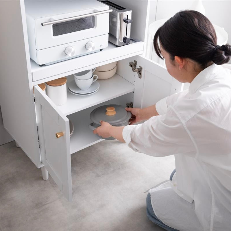 ホワイトカラーのレンジ台に鍋が収納されている