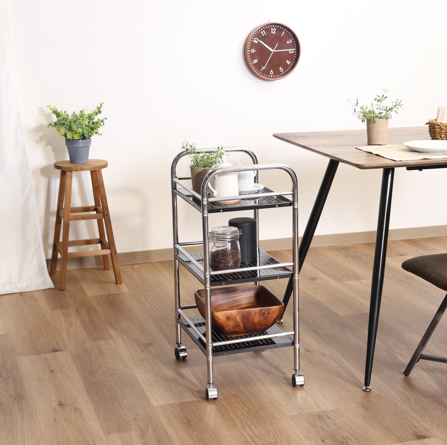 収納板がブラックのスチールワゴンをダイニングテーブルの横に置いている様子
