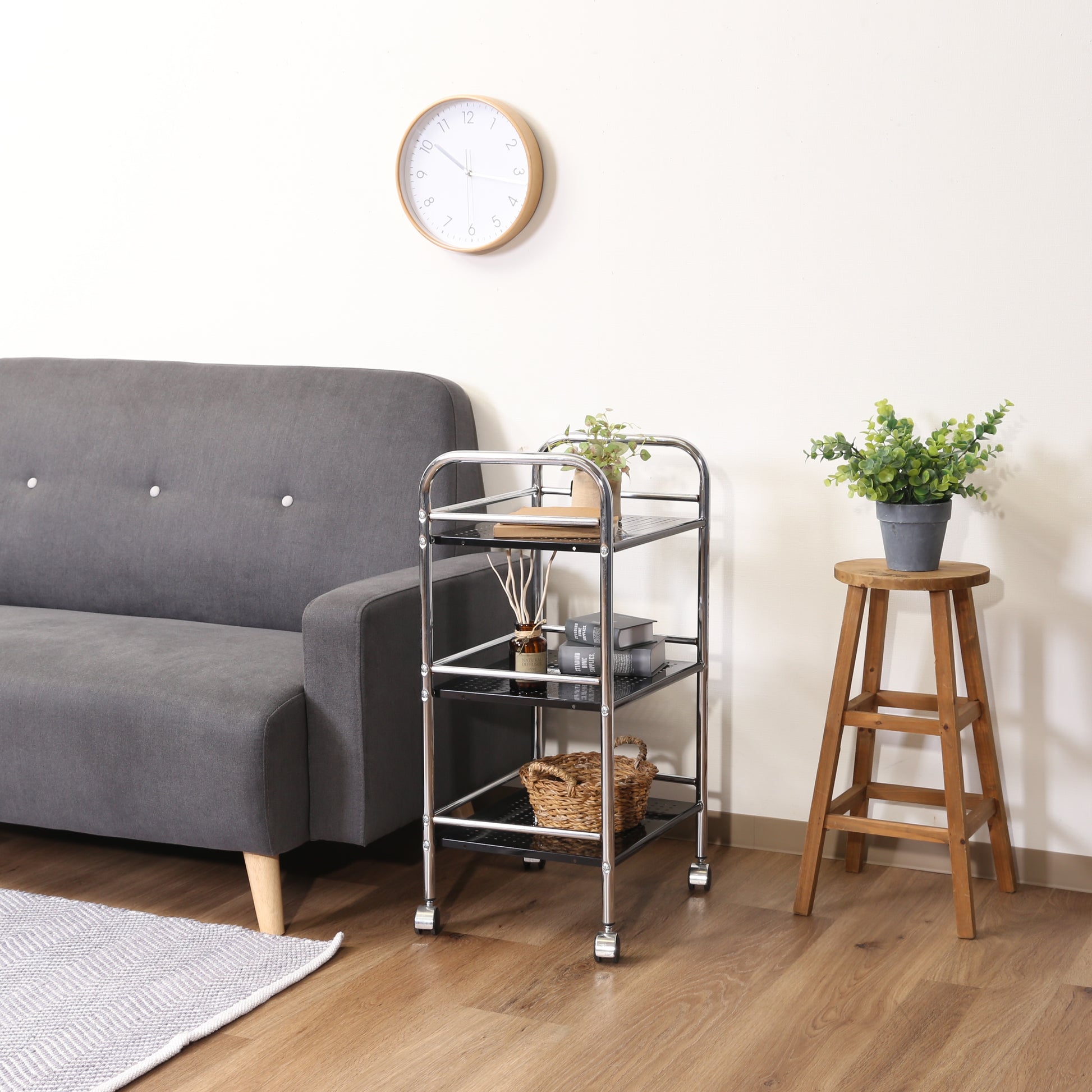 収納板がブラックのスチールワゴンをソファ横に置いている様子