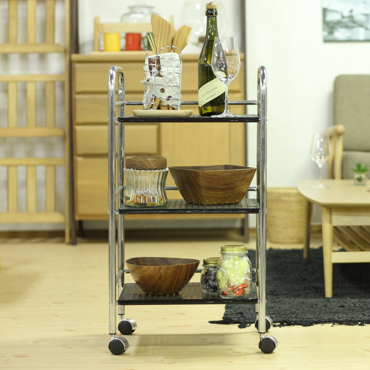 収納板がブラックのスチールワゴンにワインやグラス、食器、食料品を置いている様子