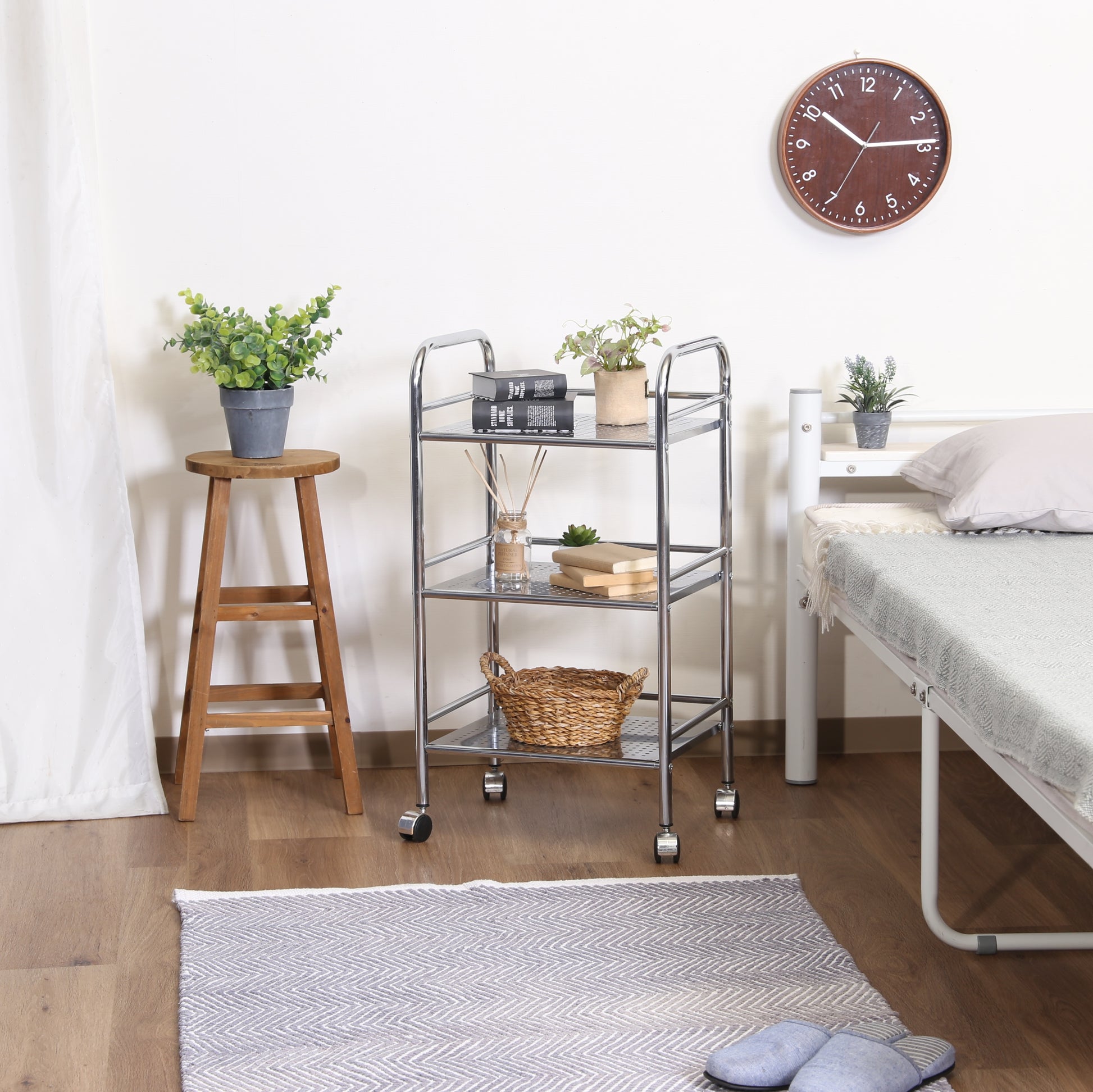 収納板がクリアのスチールワゴンをベッド横に置いている様子