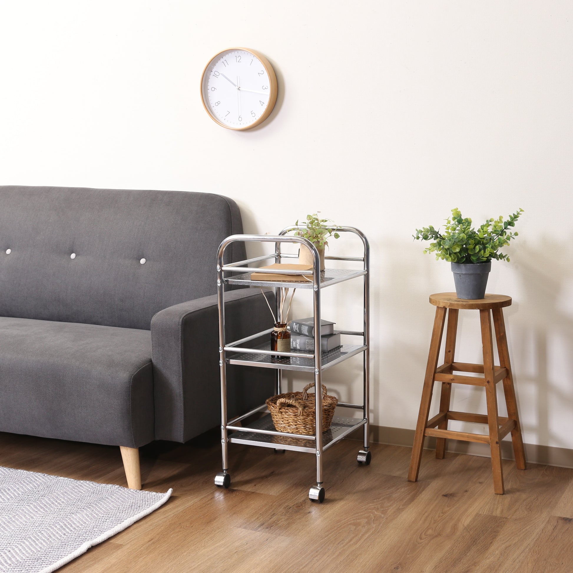 収納板がクリアのスチールワゴンをソファ横に置いている様子