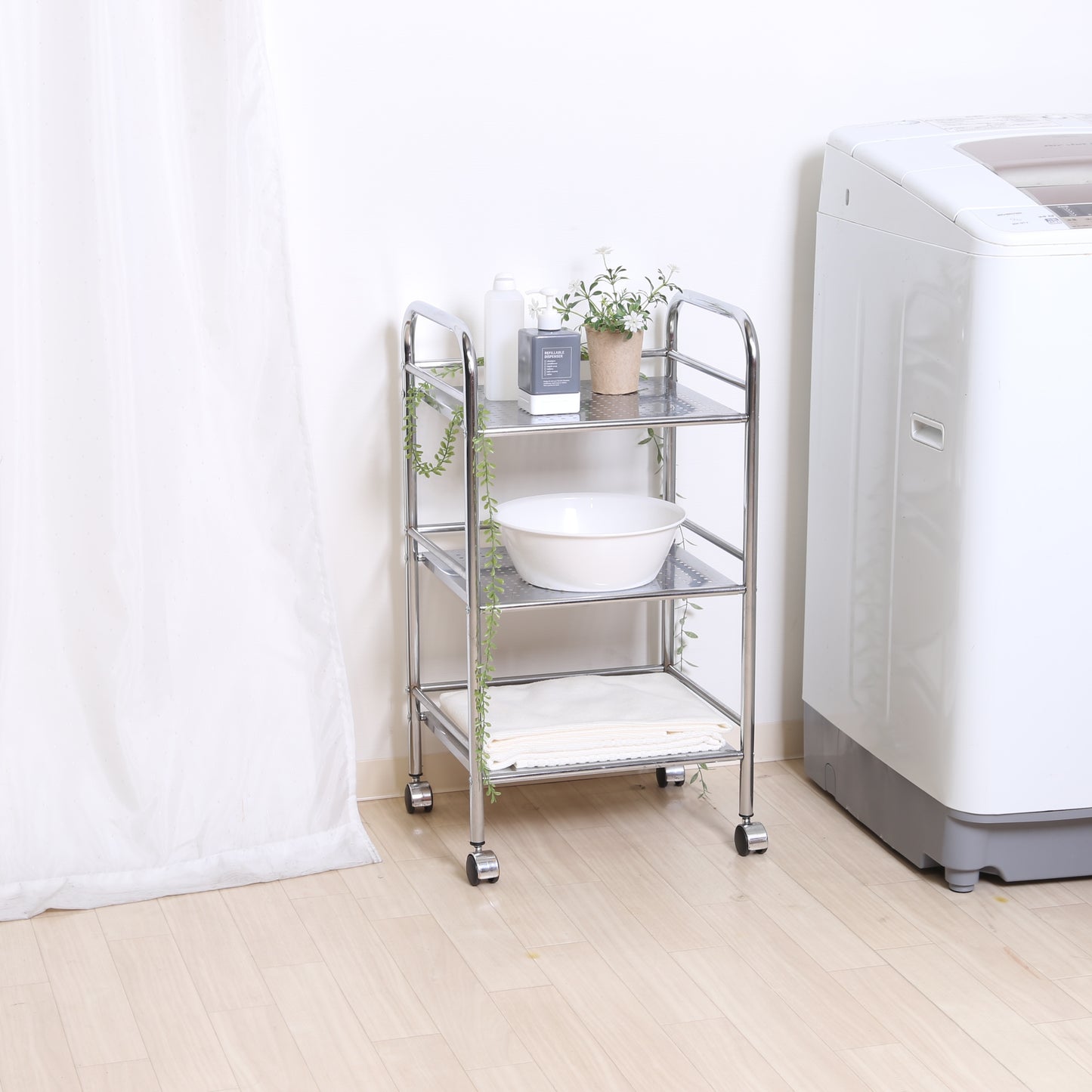 収納板がクリアのスチールワゴンを洗濯機の横に置いている様子