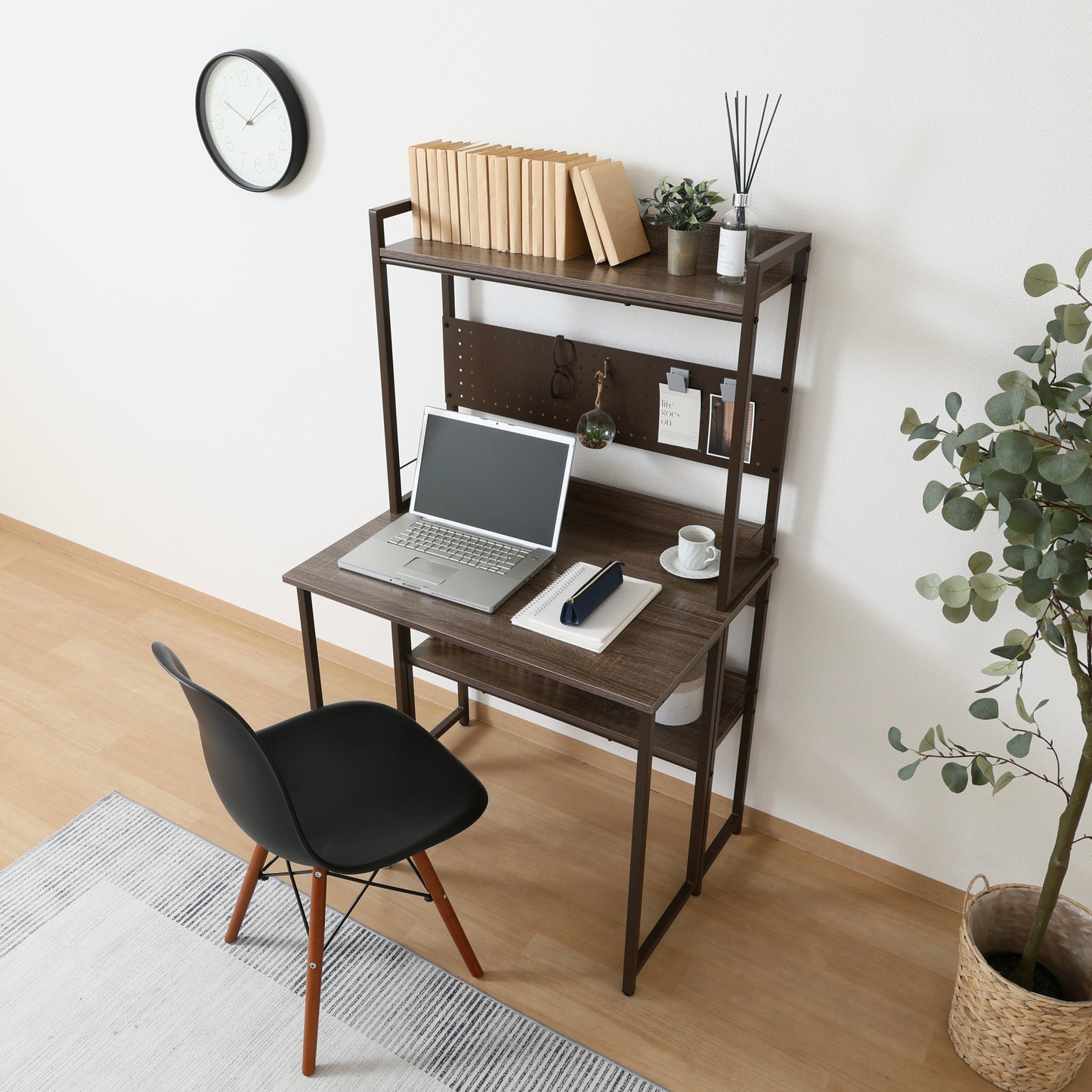 天板が折りたためる収納棚が付いたデスクにパソコンや本が置かれている様子