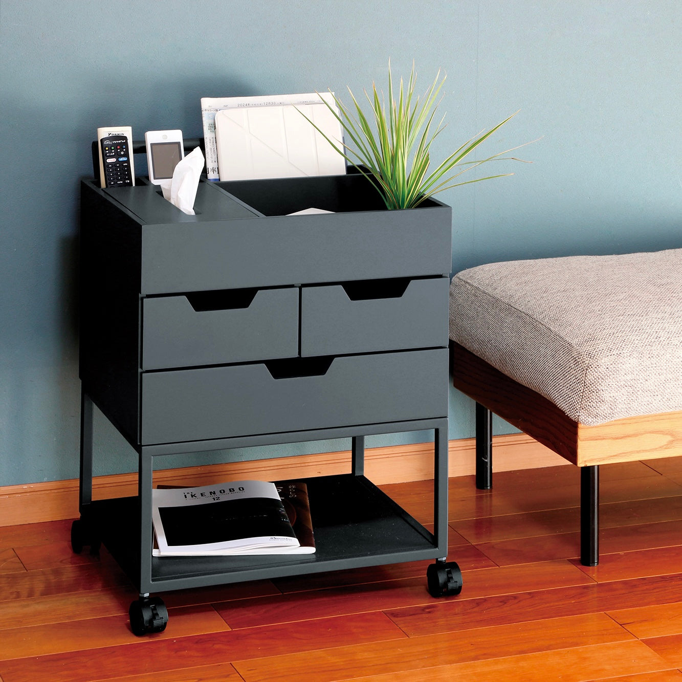 引き出しがたくさんついたネイビーのワゴンにティッシュや小物が収納されている様子