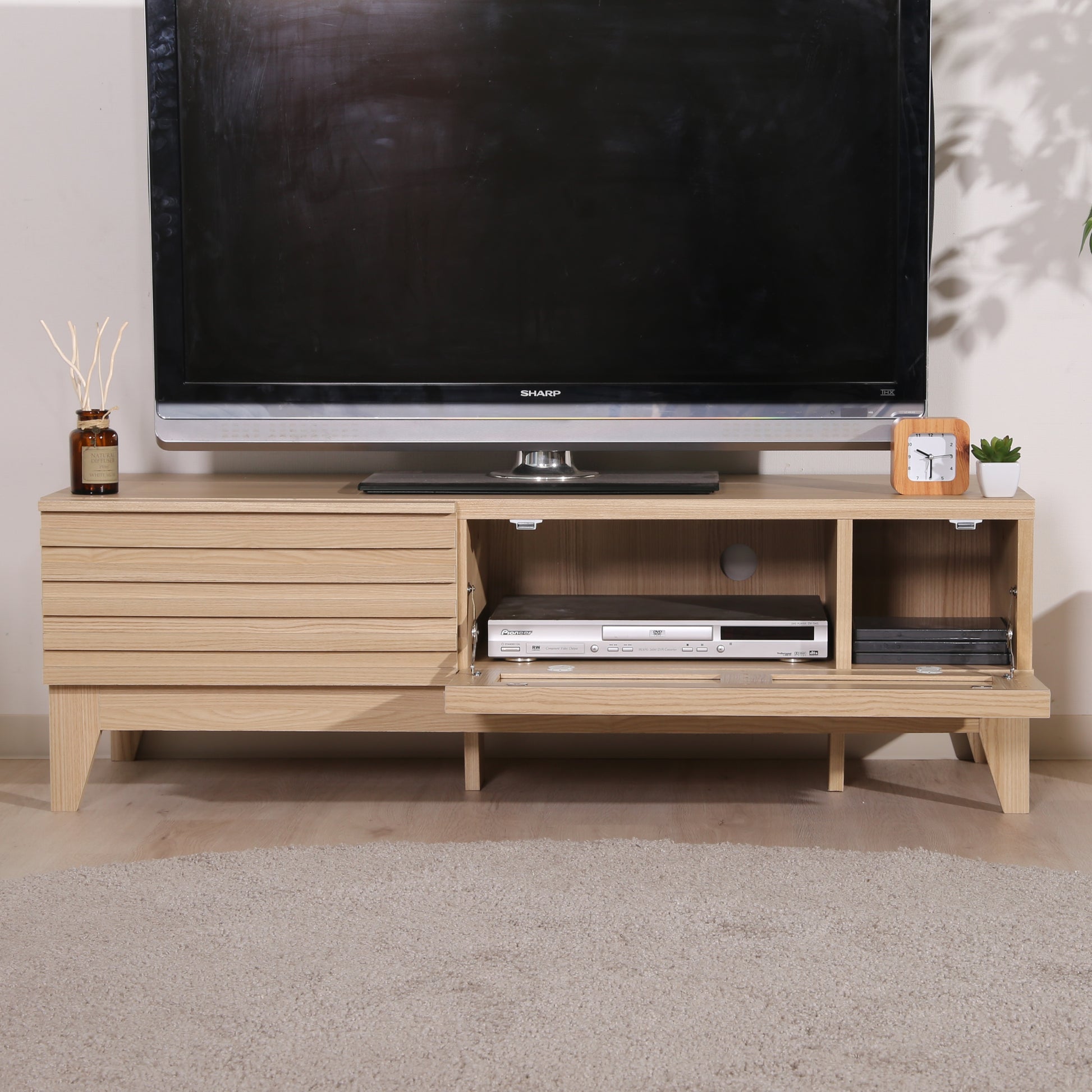 格子デザインのナチュラルウッドのテレビボードの前開き収納の中にDVDプレイヤーが入ってある