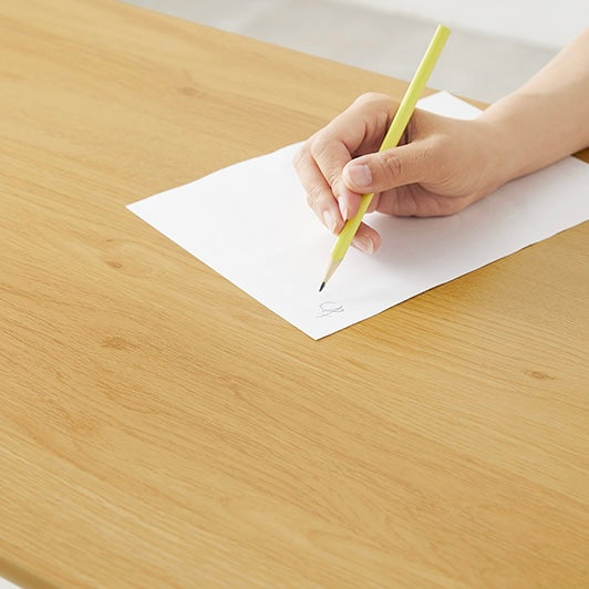 5段階に高さ調節可能なテーブルの上で書いている様子