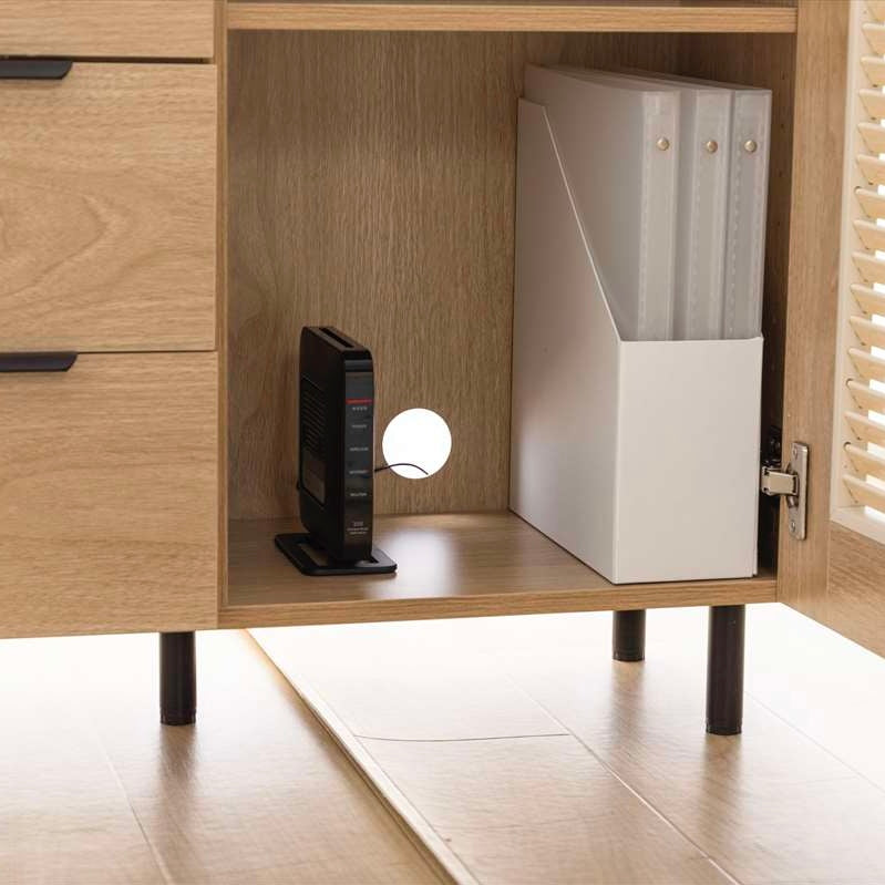 ルーバー扉とひき引き出し収納がついたキャビネットの中に収納されたルーター